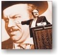 Photograph of Charles Foster Kane pointing to poster of himself.